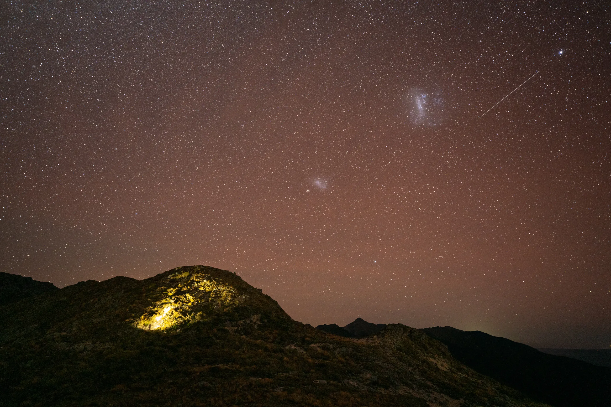 Both Magellanic Clouds and a satellite over Paparoa Range