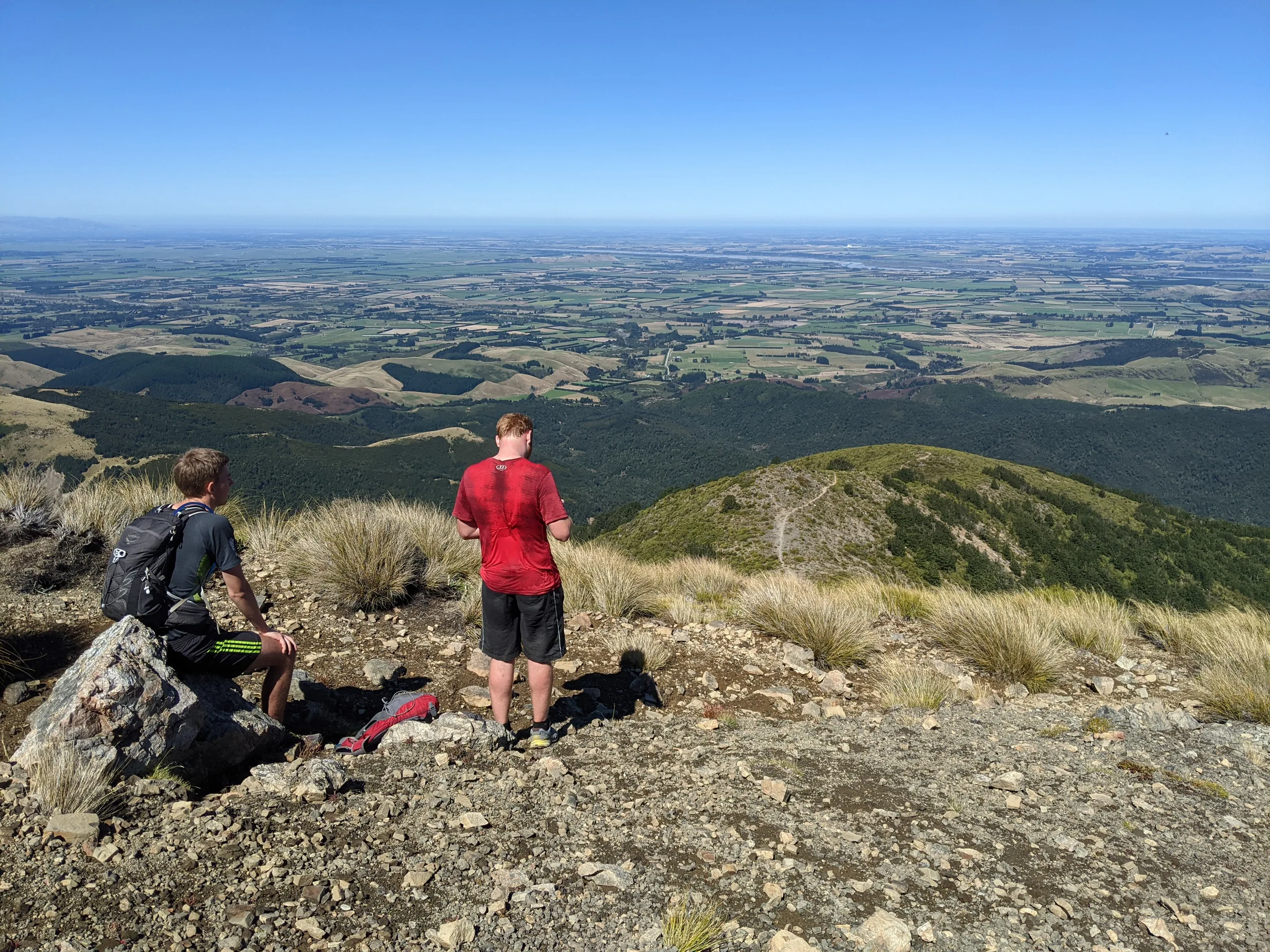 Arriving at the summit of Mt Oxford. The Canterbury Plains are laid out in front of the hill making for an expansive view across to Banks Peninsula and the coast.